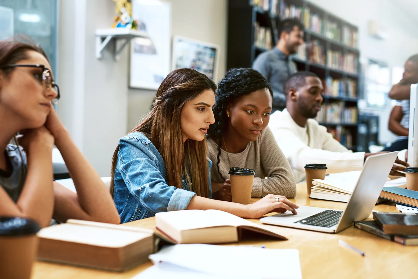 Students working together at a laptop in the library